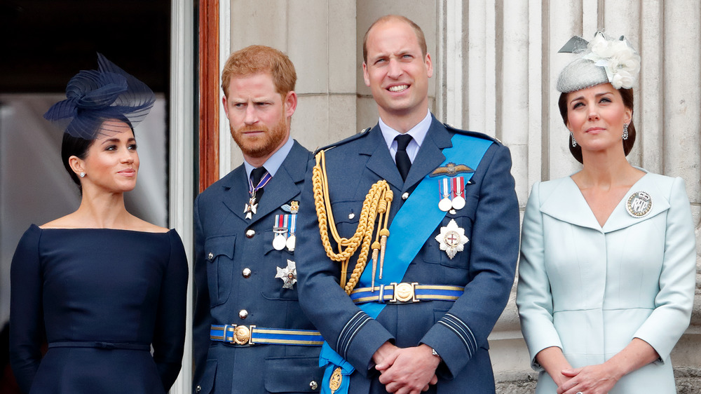 Meghan Markle, Prince Harry, Prince William, and Kate Middleton looking out at crowd