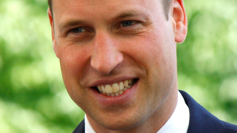 Prince Williams smiles in navy suit