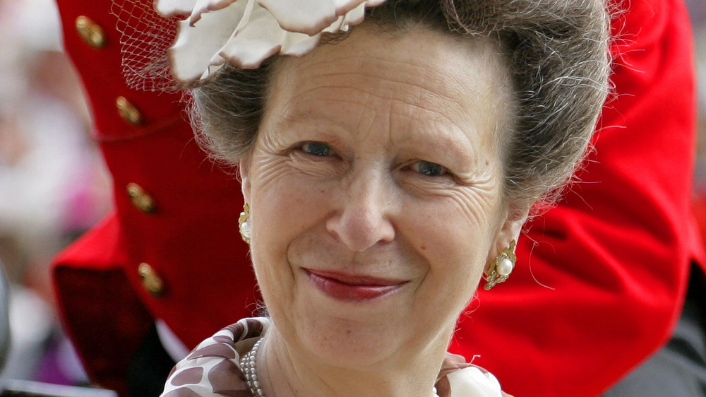 Princess Anne poses in a white hat.