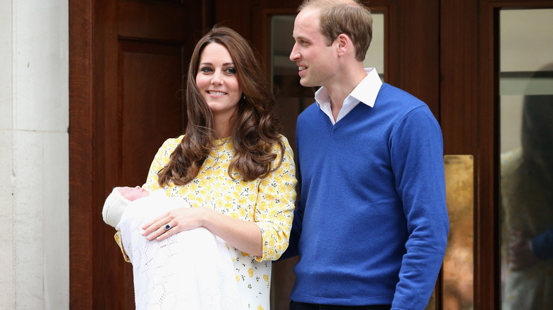 A baby Princess Charlotte with Kate and William outside the hospital where she was born