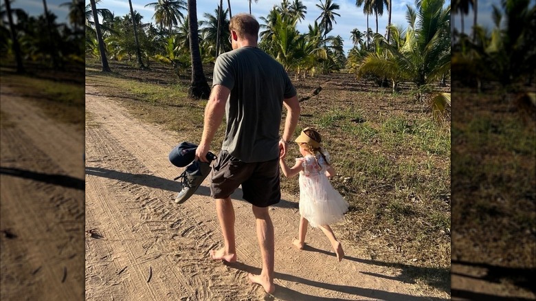 Prince Harry holding hands and walking with Princess Lilibet