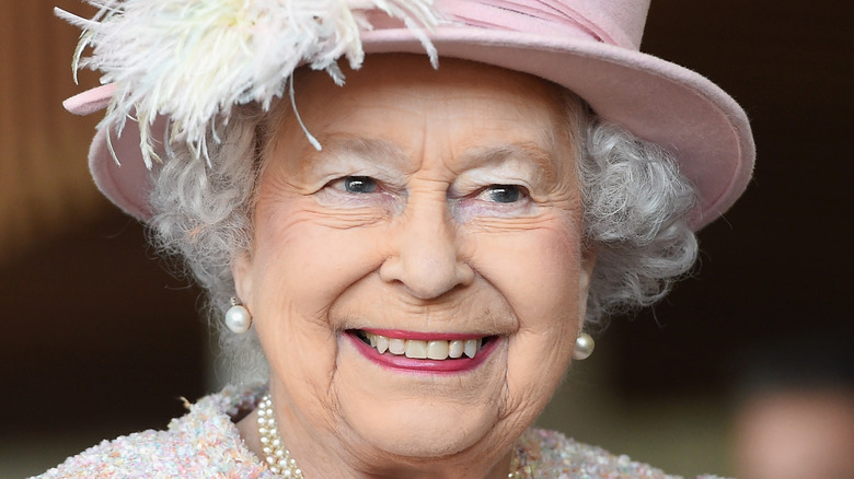 Queen Elizabeth II wearing a pink hat smiling 2017 