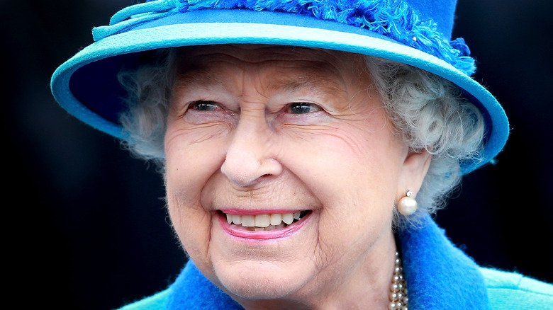 Queen elizabeth smiling in blue hat