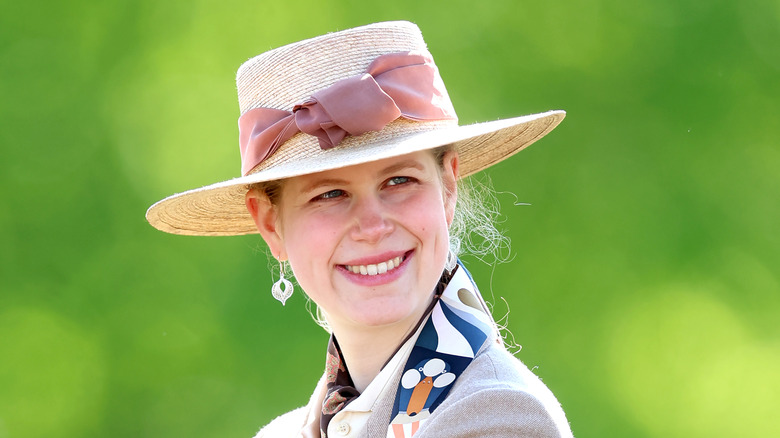 Close-up photo of Lady Louise Windsor wearing a straw hat with a pink ribbon.