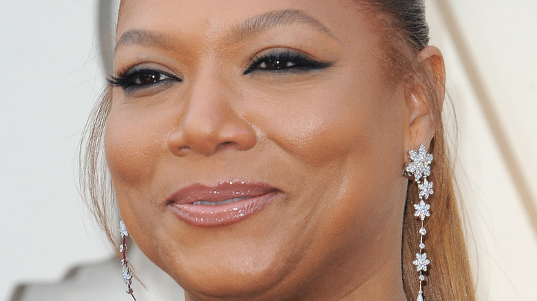 Queen Latifah smiles in drop earrings