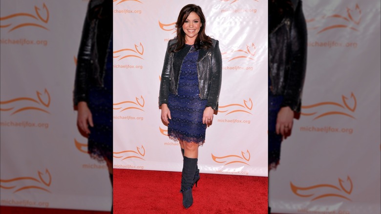 Rachael Ray in a blue knee-length dress and black leather coat.