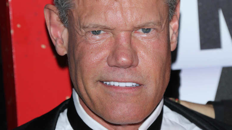 Randy Travis smiling in a suit.