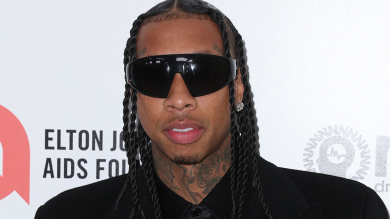 Tyga posing, wearing sunglasses