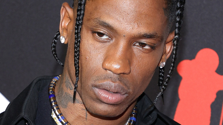 Travis Scott wearing diamond earrings