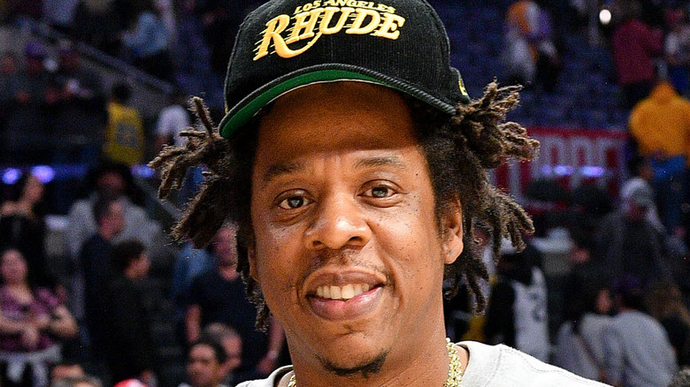 Jay-Z wearing a black cap and smiling