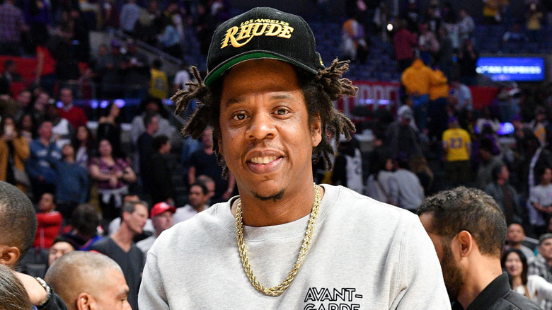 Jay-Z wearing a black cap and smiling