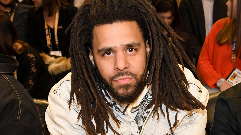 J. Cole seated and posing