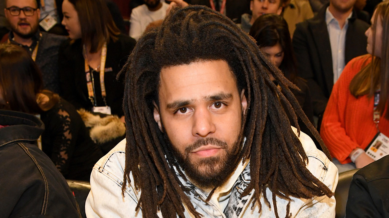 J. Cole seated and posing