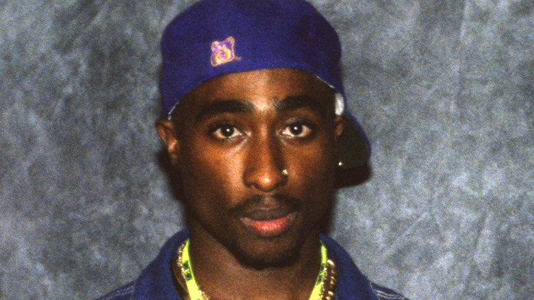 Tupac Shakur wearing a blue cap