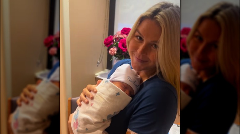 Karoline Leavitt smiles at the camera while holding her newborn son.