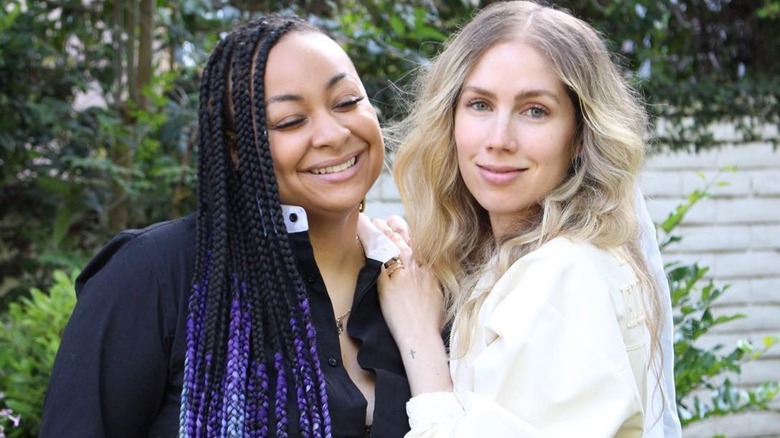 Raven-Symoné leans toward Miranda Maday while all smiles, as Maday looks at the camera while resting her hand on Symoné's shoulder.