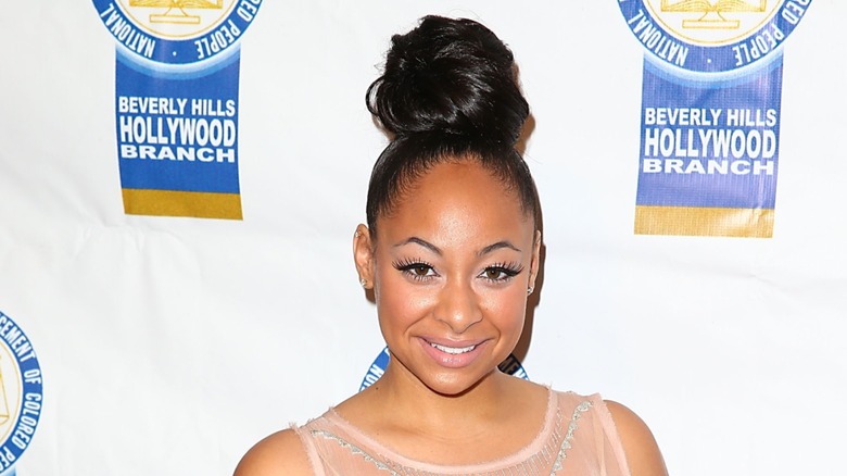 Raven-Symoné delightedly glares at the camera while wearing her hair in a bun.