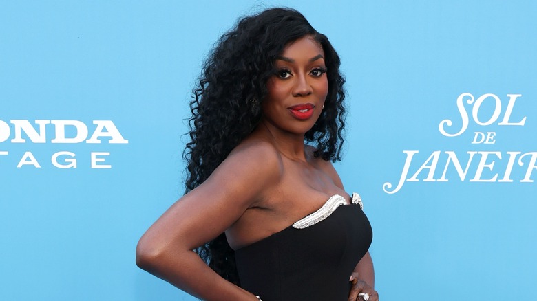 Wendy Osefo posing in front of a blue background