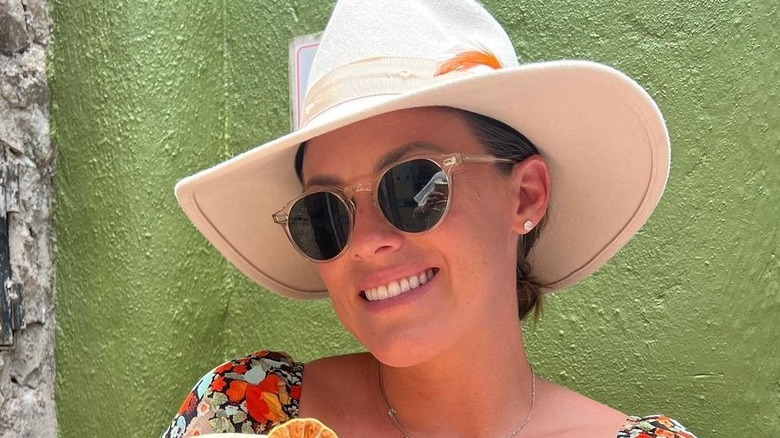 Kara Keough smiles while holding a drink