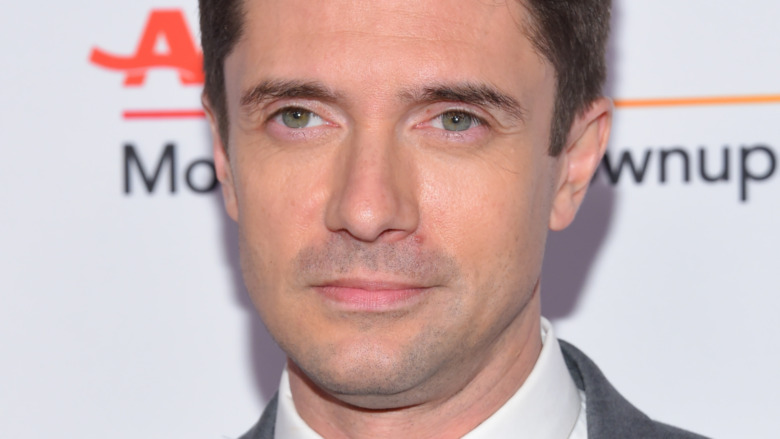 Topher Grace smirking 