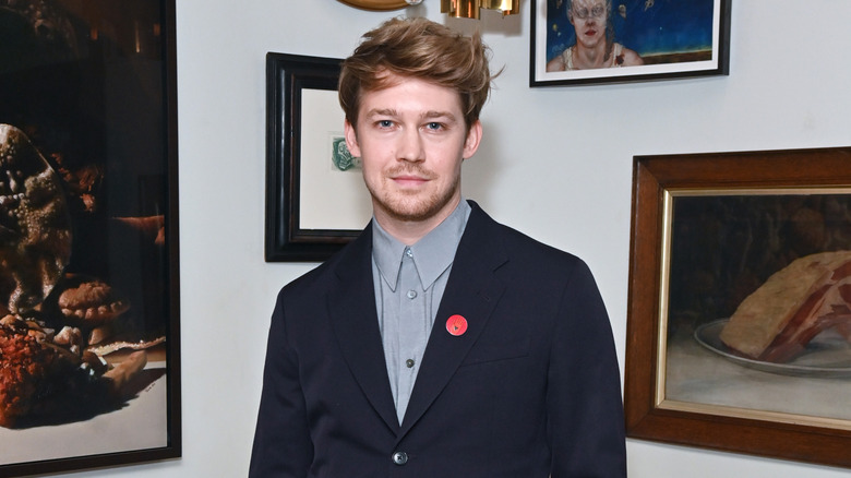 Joe Alwyn posing with art
