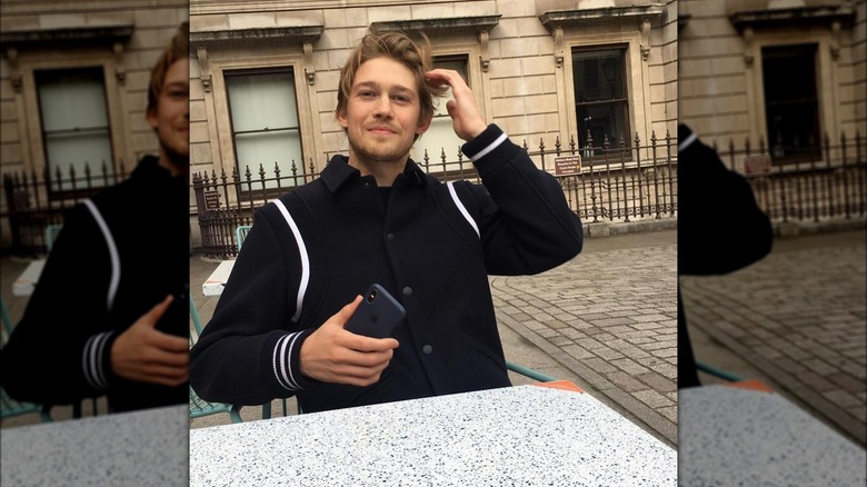 Joe Alwyn holding phone