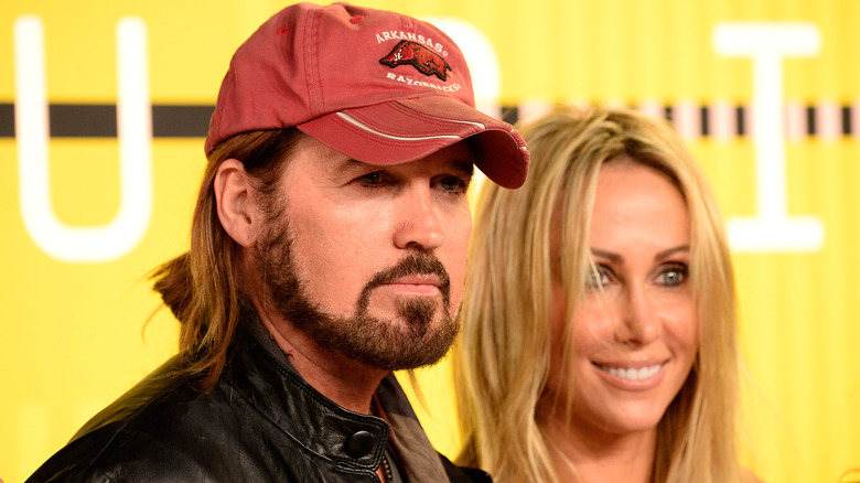 Billy Ray and Tish Cyrus stand together at red carpet event