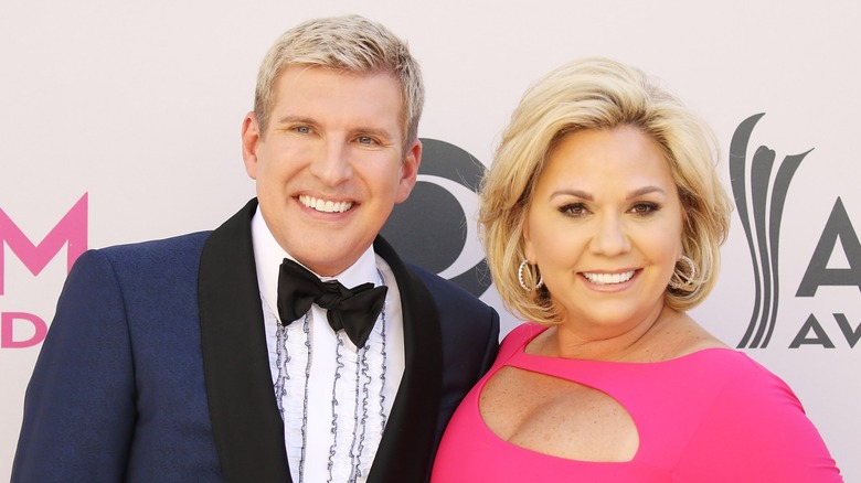 Todd Chrisley leans towards Julie Chrisley as the duo pastes wide smiles on the red carpet.