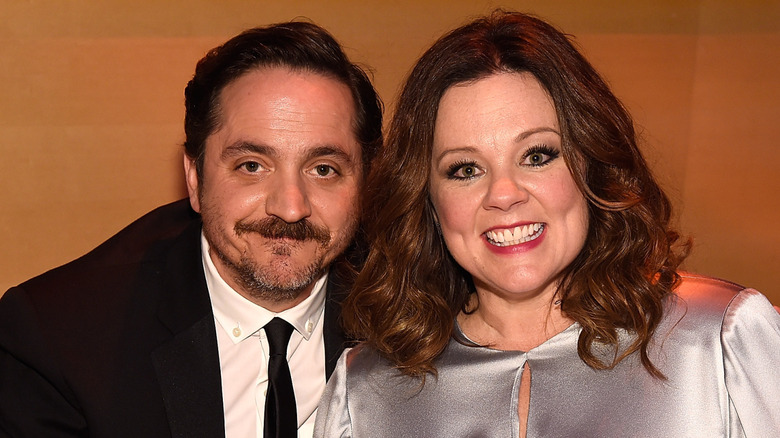 Melissa McCarthy and Ben Falcone posing together at a table.