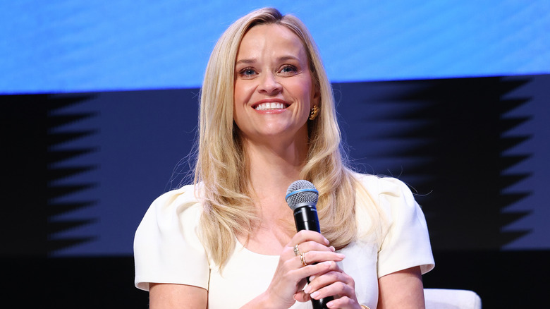 Reese Witherspoon holds a microphone onstage