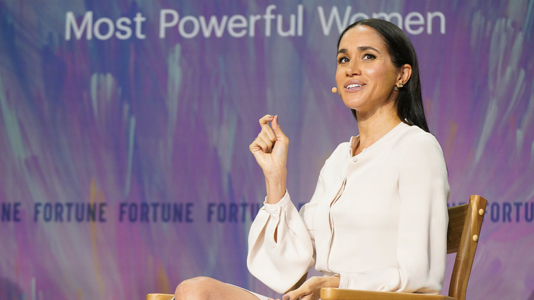 Meghan Markle seated and wearing a cream-colored blouse at the Fortune Most Powerful Women Summit 2025.