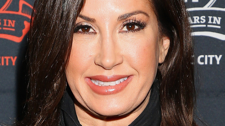 Jacqueline Laurita smiles and wears a black top