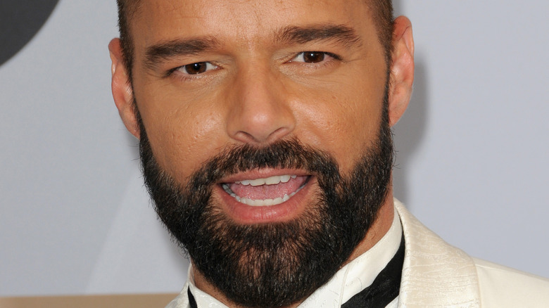 Ricky Martin in a white tuxedo walking the red carpet