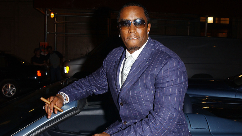 Diddy sitting on car cigar
