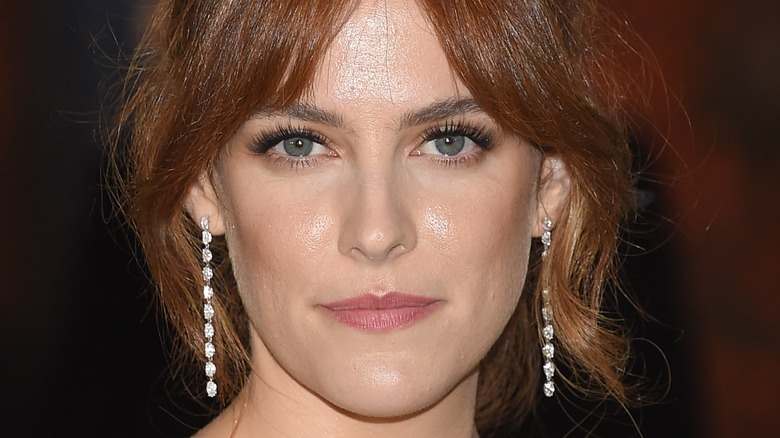 Riley Keough wearing dangling diamond earrings