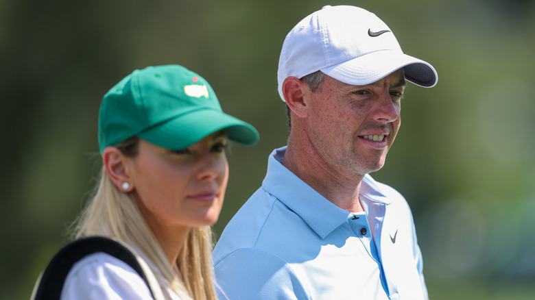 Erica Stoll and Rory McIlroy wearing baseball caps