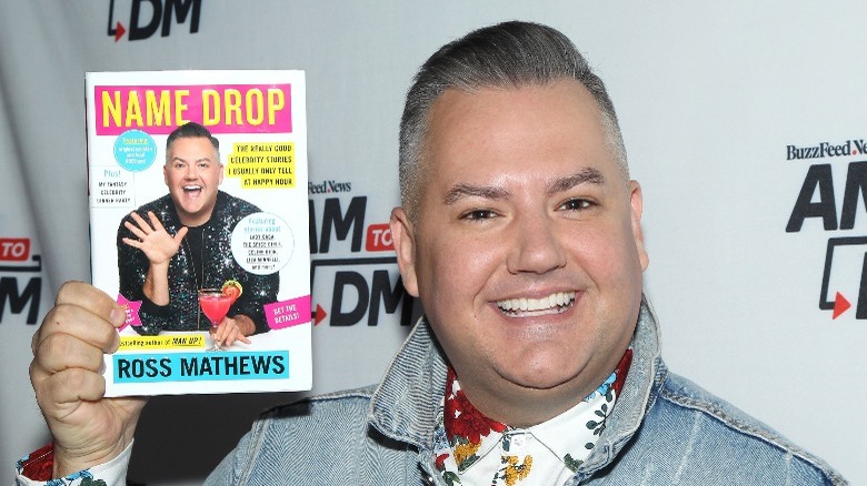 Ross Mathews holding his book 