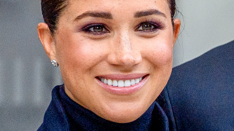 Meghan Markle with wide smile and hair pulled back