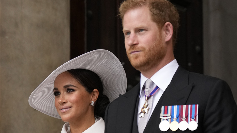 Prince Harry and Meghan Markle looking solemn