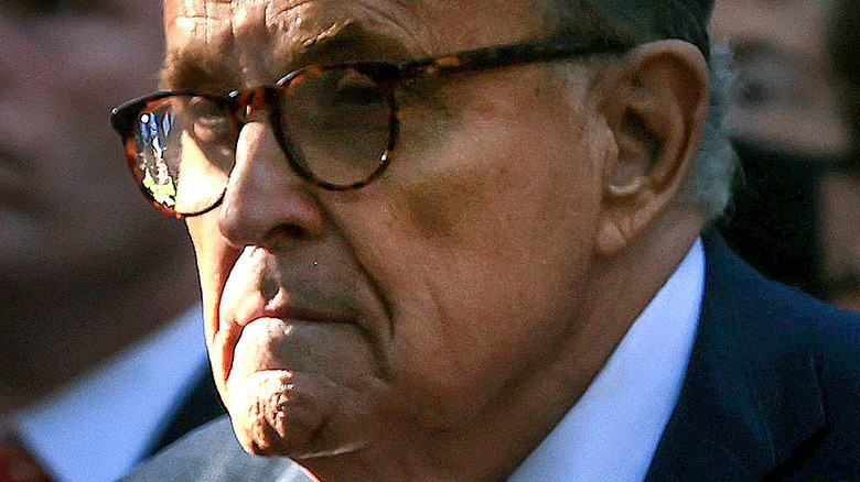 Rudy Giuliani side profile with glasses and serious expression