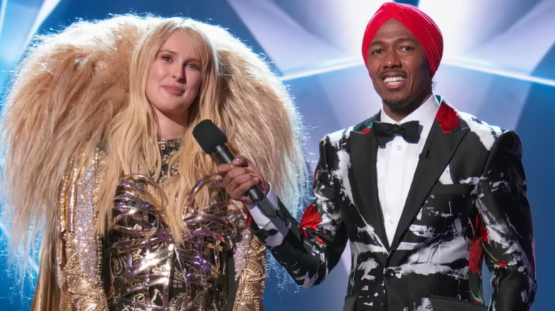 Rumer Willis wearing gold costume beside Nick Cannon
