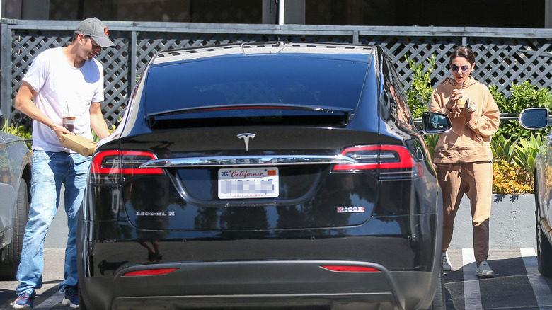 Ashton Kutcher and Mila Kunis getting into Tesla