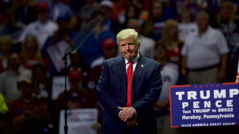 Donald Trump at a rally with a Trump/Pence sign