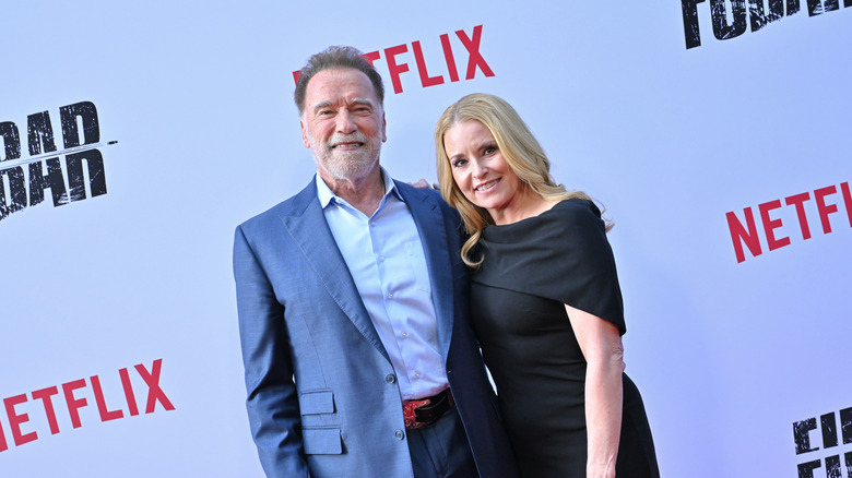 Arnold Schwarzenegger and Heather Milligan pose at the FUBAR premiere in 2025.