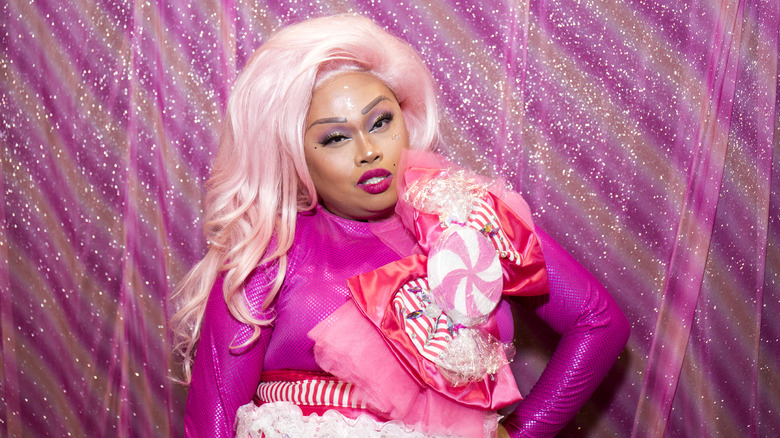 Drag queen Jiggly Caliente in a pink embellished long sleeved jumpsuit