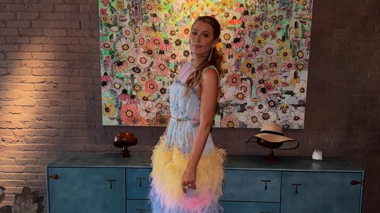 Blake Lively poses in floral-themed outfit and setting while promoting It Ends with Us