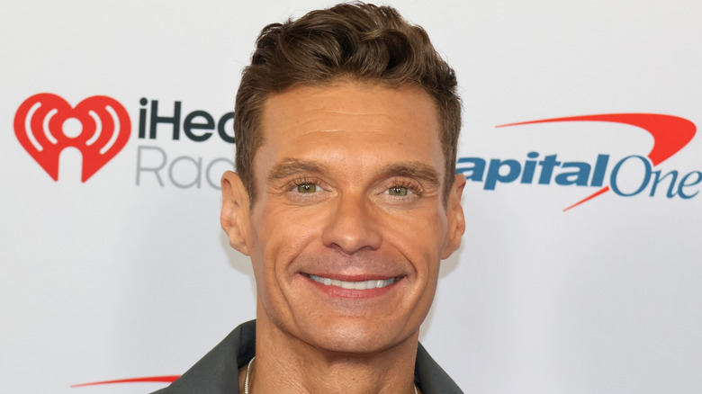 Ryan Seacrest smiling on red carpet