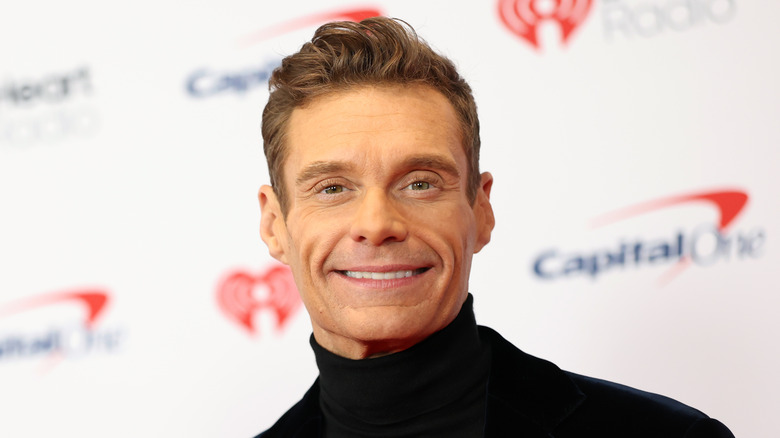 Ryan Seacrest smiles on the red carpet.
