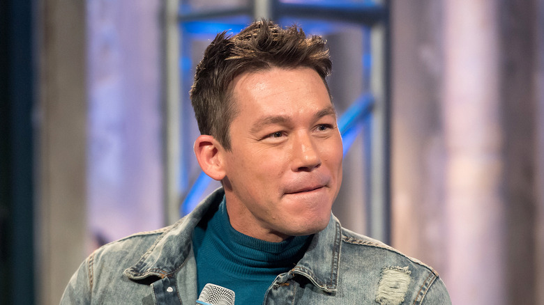 David Bromstad listens while holding mic
