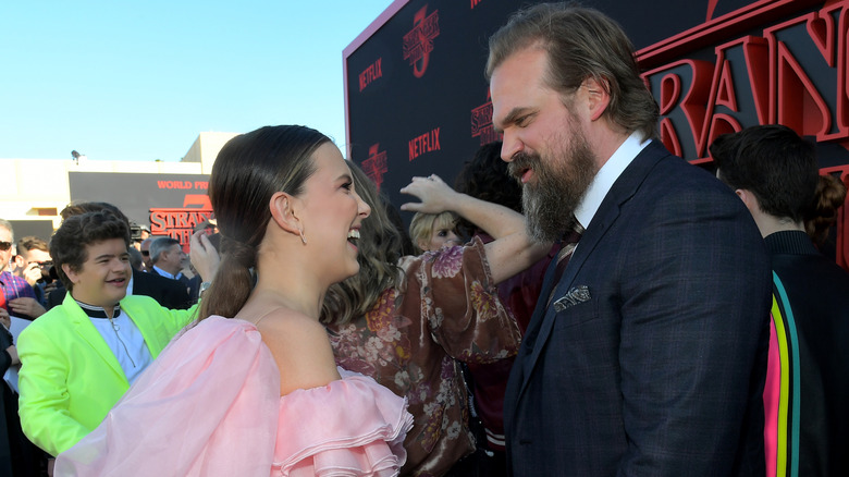 Millie Bobby Brown and David Harbour speaking at a Stranger Things event.